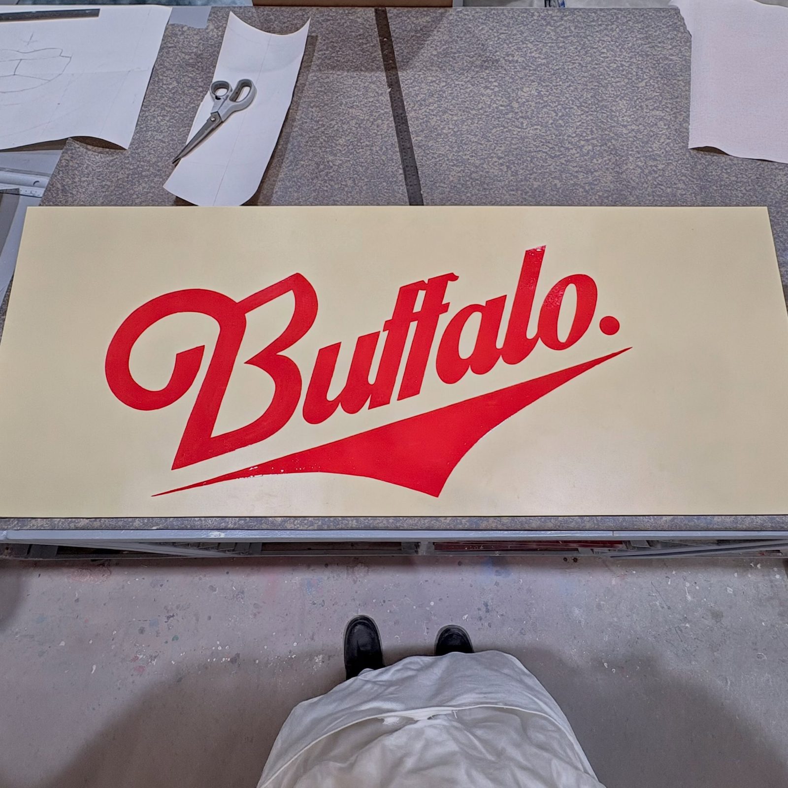 Hand-painted red Buffalo script sign on a cream panel Hand-painted red Buffalo script sign on a cream panel