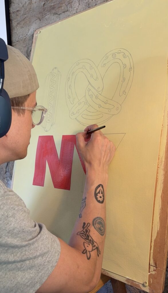 Torin sketching the I love NY lettering onto a cream board