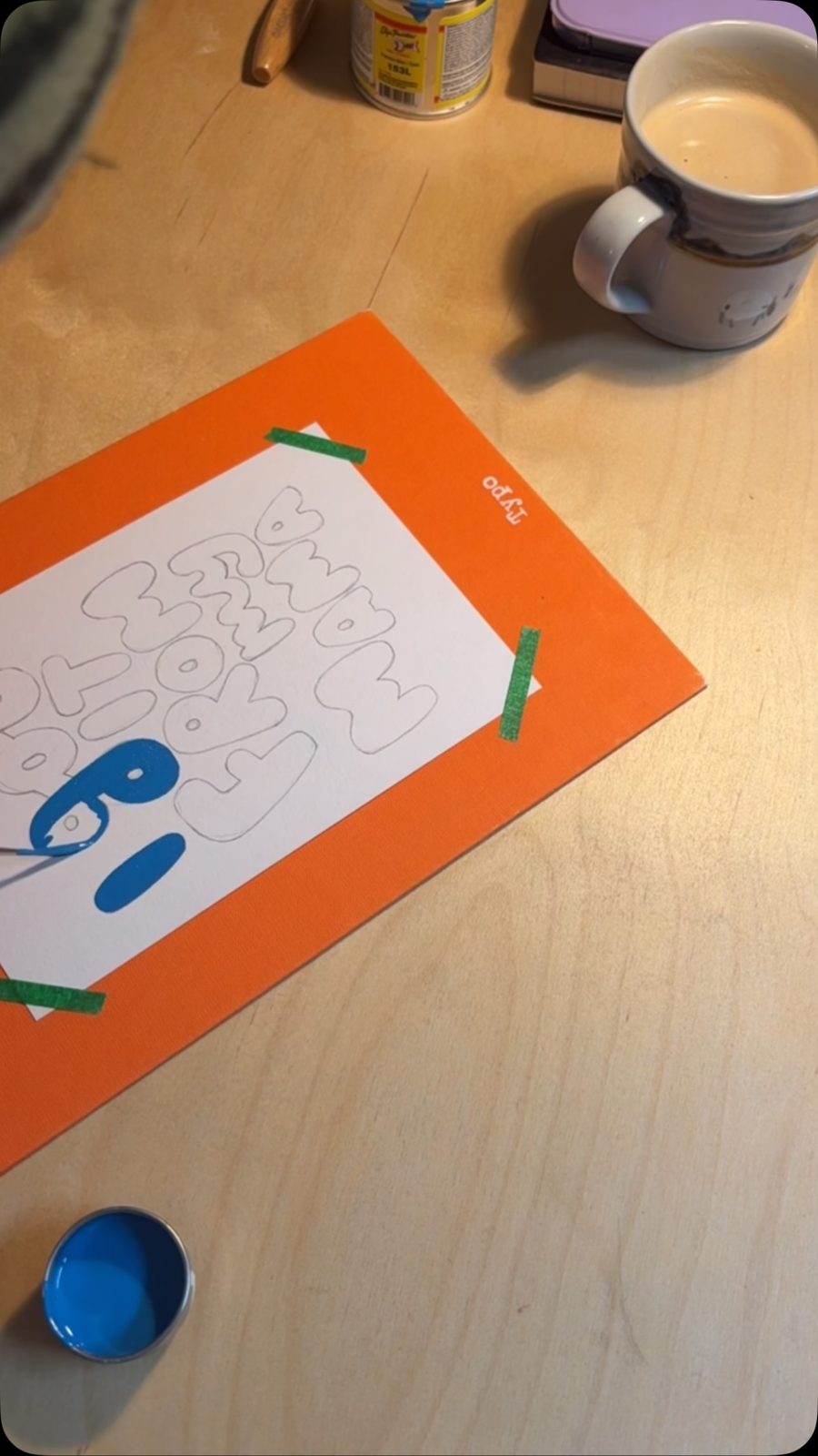Blue bubble letters being painted over a pencil sketch